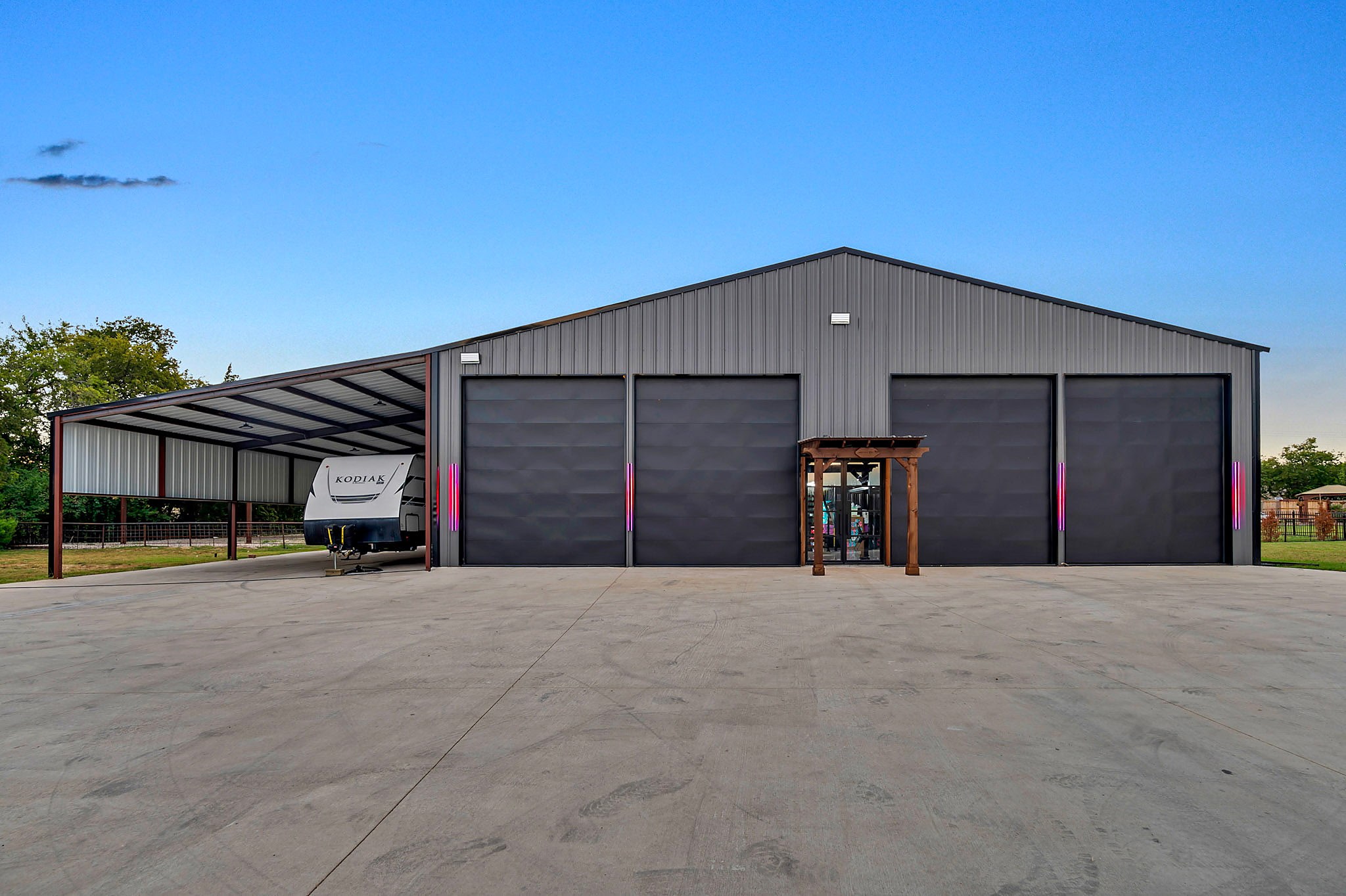Grey metal shop with an RV parked under the lean to