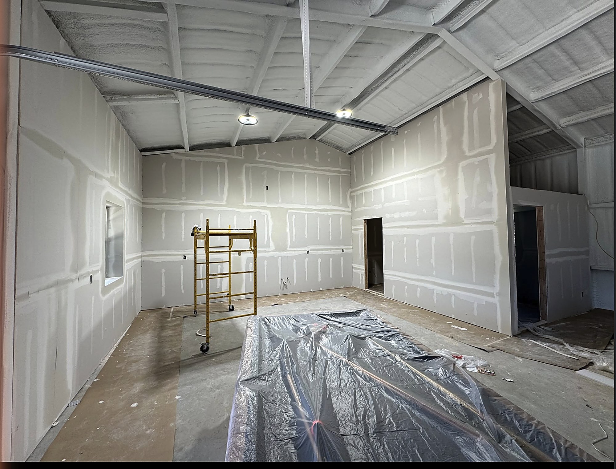 Interior of a 40x60 metal building with spray foam, drywall taped and floated